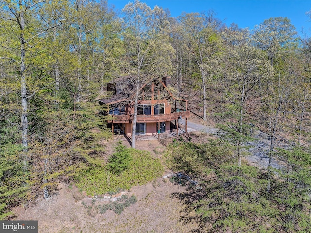 birds eye view of property featuring a forest view