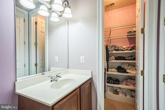 6041 Clairemont Dr, Owings, MD 20736 - bathroom featuring visible vents, an inviting chandelier, vanity, and a walk in closet