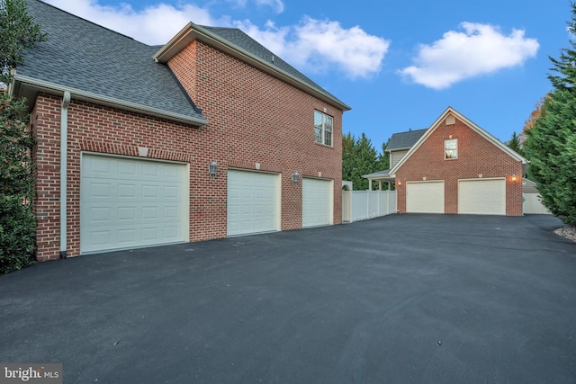 6041 Clairemont Dr, Owings, MD 20736 - view of side of home featuring brick siding, a shingled roof, a garage, and aphalt driveway
