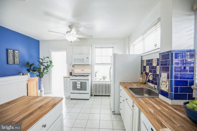 kitchen featuring ceiling fan, a sink, radiator, white appliances, and butcher block countertops