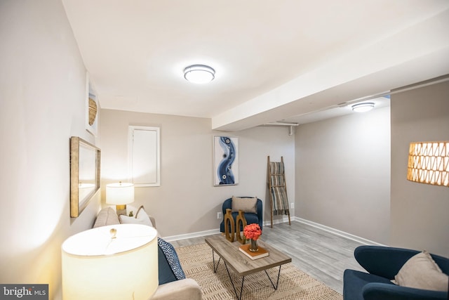 living area with baseboards and wood finished floors