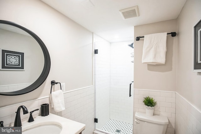 full bathroom with a sink, toilet, tile walls, a shower stall, and visible vents