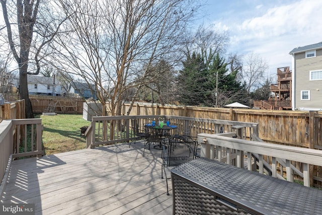 deck with a yard, outdoor dining area, and a fenced backyard
