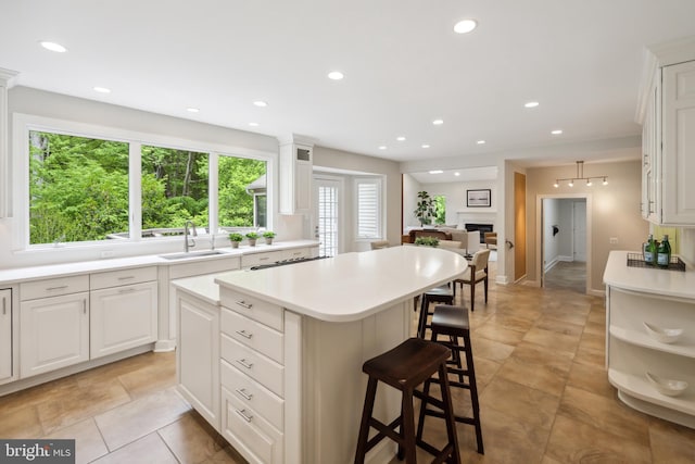 6530 Heather Brook Ct, Mclean, VA 22101 - kitchen with a kitchen island, white cabinetry, a breakfast bar, and a sink