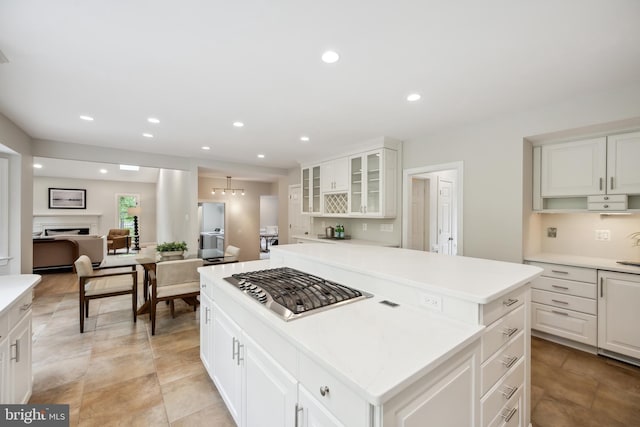 6530 Heather Brook Ct, Mclean, VA 22101 - kitchen with stainless steel gas cooktop, light countertops, a center island, recessed lighting, and glass insert cabinets