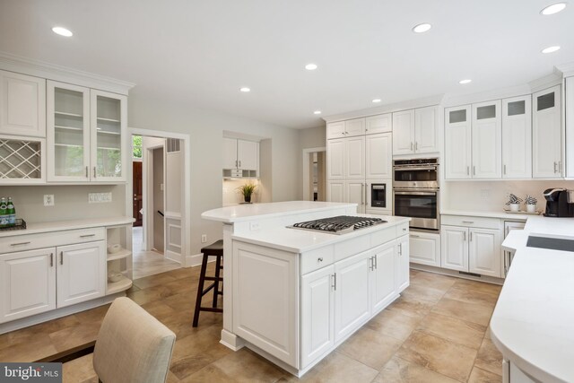 6530 Heather Brook Ct, Mclean, VA 22101 - kitchen featuring appliances with stainless steel finishes, light countertops, a breakfast bar area, a center island, and recessed lighting