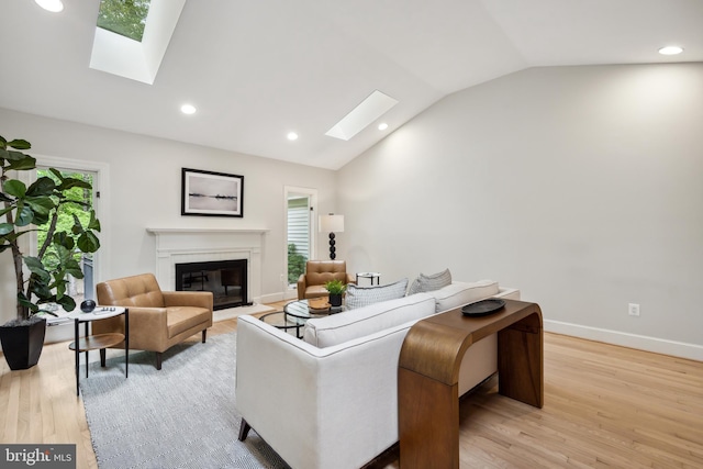 6530 Heather Brook Ct, Mclean, VA 22101 - living room with a glass covered fireplace, recessed lighting, light wood finished floors, and lofted ceiling with skylight