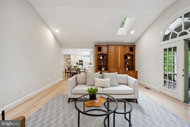6530 Heather Brook Ct, Mclean, VA 22101 - living area with visible vents, light wood-style flooring, baseboards, and vaulted ceiling with skylight