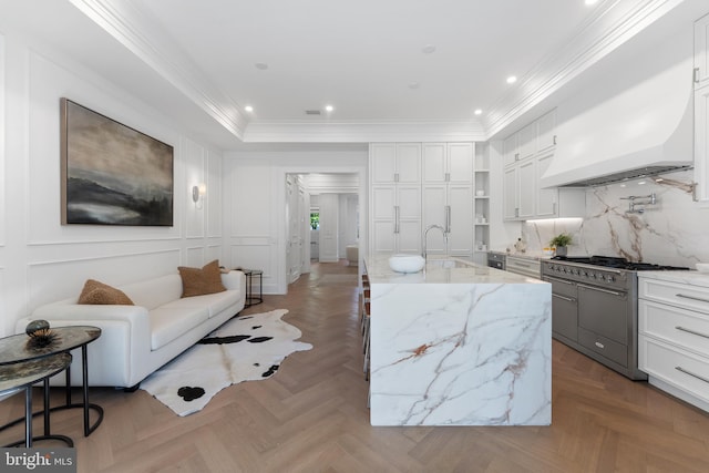 living area with crown molding, recessed lighting, and a decorative wall