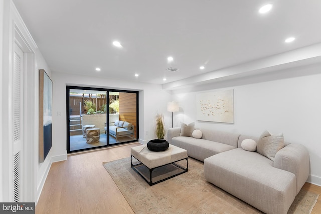 living room featuring recessed lighting, baseboards, visible vents, and light wood-type flooring