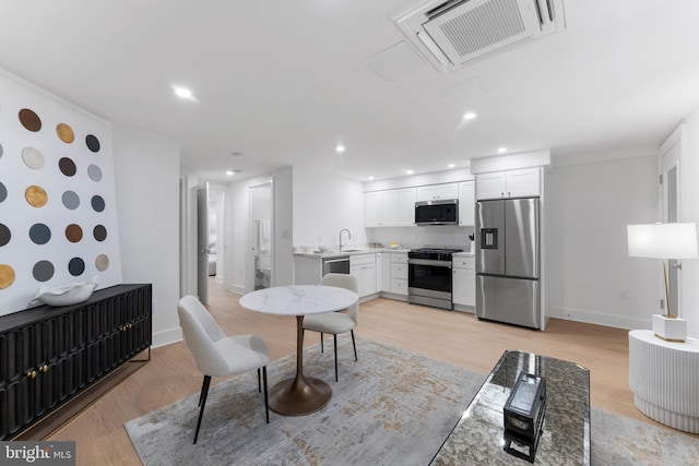 dining room featuring radiator heating unit, recessed lighting, light wood-type flooring, and visible vents