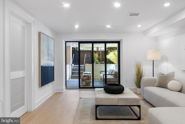 living room with baseboards, recessed lighting, wood finished floors, and visible vents