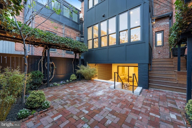 rear view of house with brick siding, fence, and a patio area