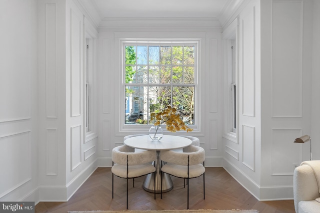 dining area with ornamental molding and a decorative wall
