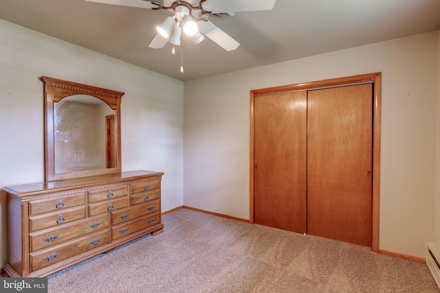 carpeted bedroom featuring a closet, baseboards, baseboard heating, and a ceiling fan