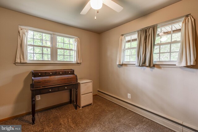 office featuring baseboard heating, healthy amount of natural light, a ceiling fan, and baseboards