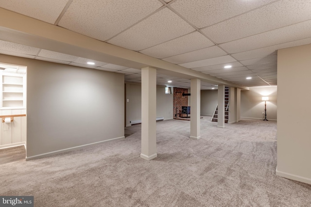 finished basement with carpet, a paneled ceiling, recessed lighting, baseboards, and a baseboard heating unit