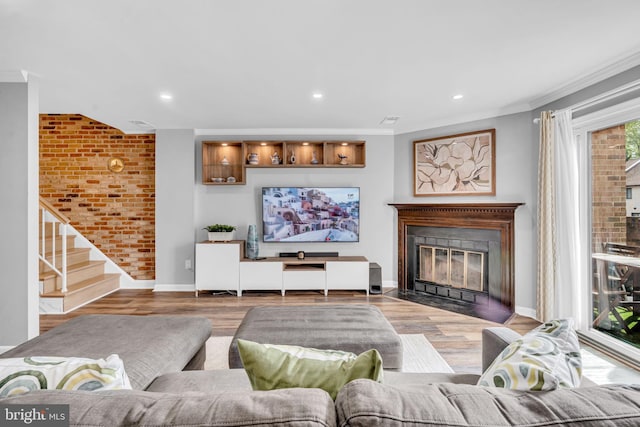 living area featuring baseboards, recessed lighting, wood finished floors, and a fireplace with flush hearth