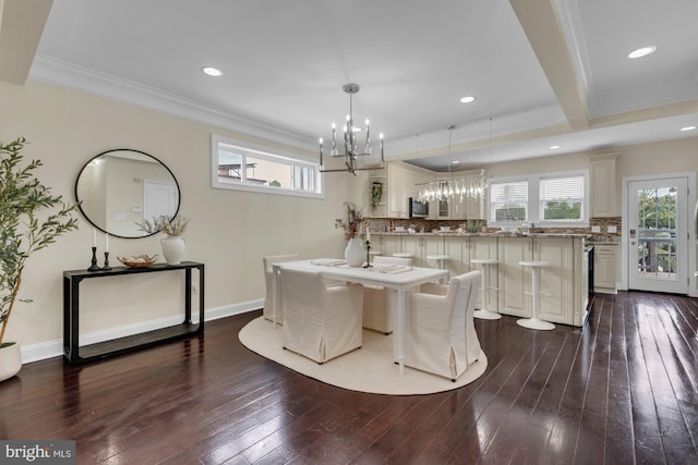 dining room with an inviting chandelier, dark wood-style flooring, a wealth of natural light, and ornamental molding