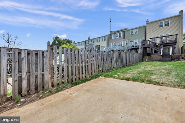 view of patio featuring fence, stairway, a deck, and a residential view