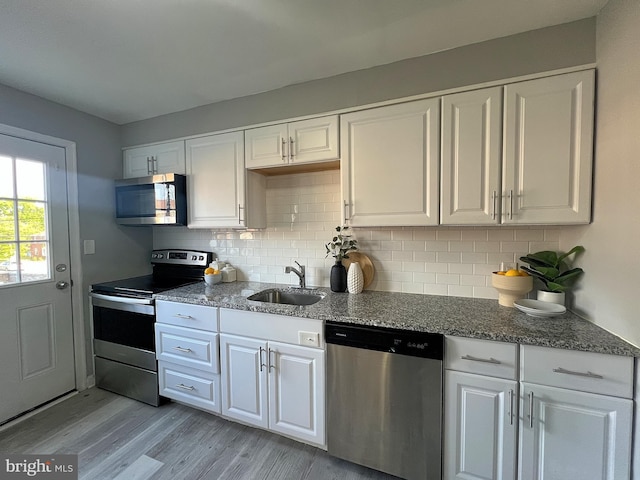 kitchen with appliances with stainless steel finishes, white cabinetry, and a sink