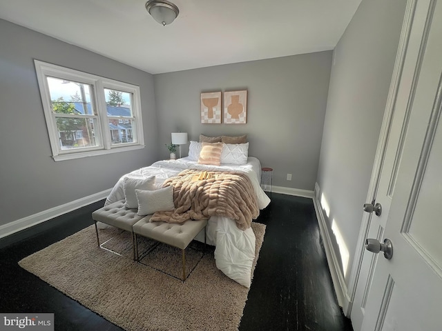 bedroom with baseboards and dark wood-style flooring
