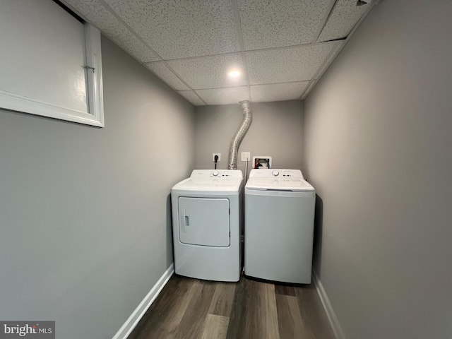 clothes washing area featuring separate washer and dryer, dark wood-style floors, baseboards, and laundry area