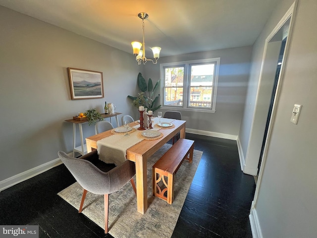 dining room with a chandelier, wood finished floors, and baseboards