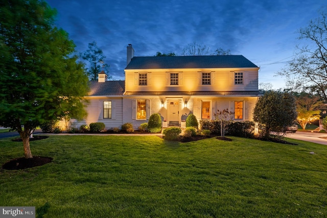 traditional-style house with a front lawn and a chimney