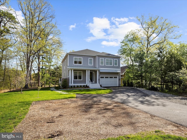 traditional-style home featuring aphalt driveway, a front yard, board and batten siding, metal roof, and an attached garage
