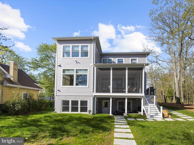 back of house with a sunroom, a lawn, and stairway