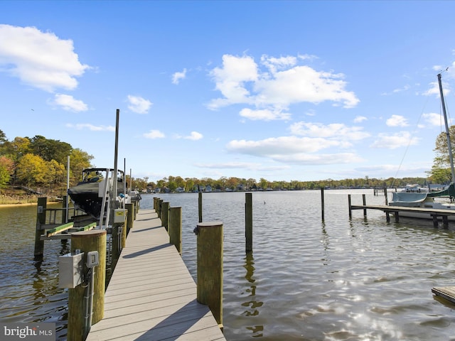 dock area with boat lift and a water view