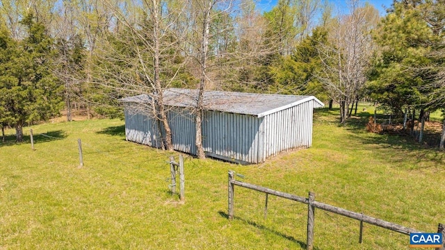view of outbuilding featuring fence and an outbuilding