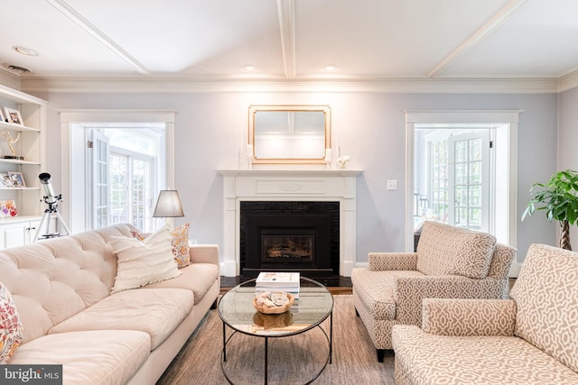 living room with crown molding, wood finished floors, and a fireplace
