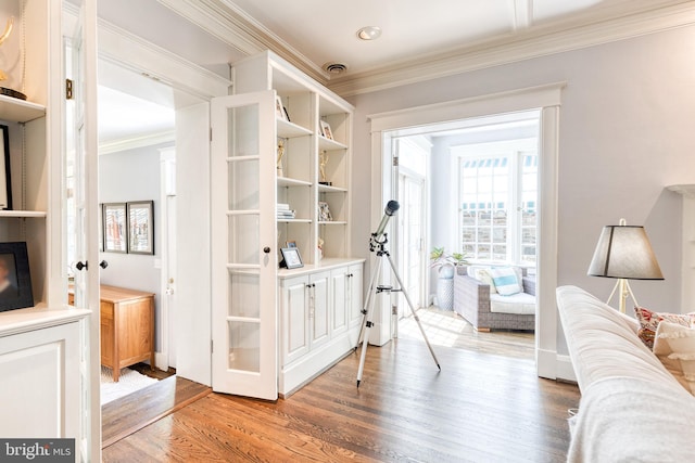 interior space with ornamental molding and light wood finished floors