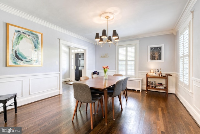 dining space featuring crown molding, an inviting chandelier, dark wood-style floors, and a decorative wall