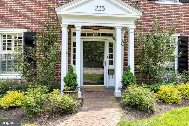 doorway to property featuring brick siding
