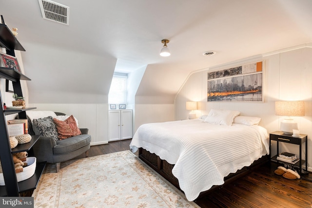bedroom with visible vents, wood finished floors, and vaulted ceiling
