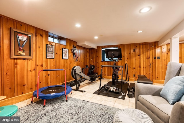 workout room featuring light tile patterned floors, recessed lighting, baseboards, and wood walls