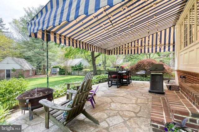 view of patio / terrace featuring a fenced backyard, outdoor dining area, an outdoor fire pit, and area for grilling