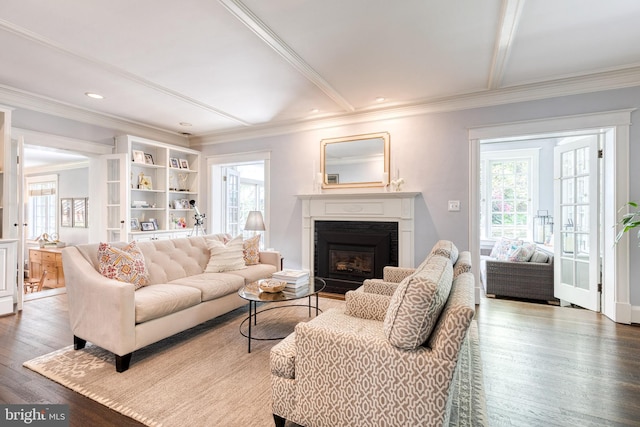 living room featuring ornamental molding, a glass covered fireplace, wood finished floors, beamed ceiling, and recessed lighting