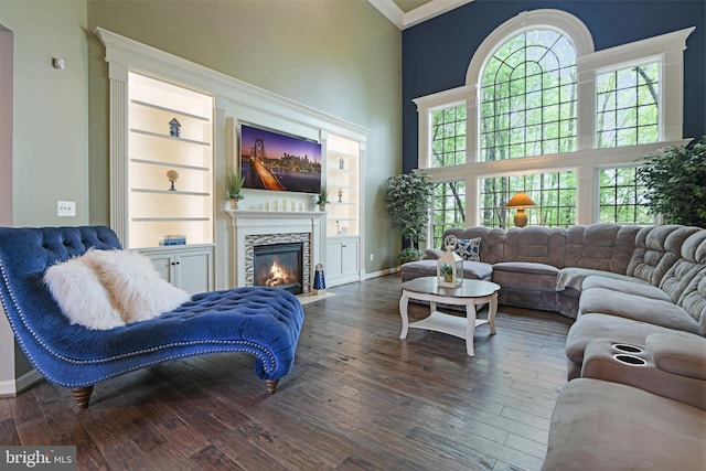 living room with baseboards, a fireplace with flush hearth, and hardwood / wood-style floors
