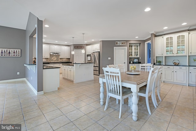 dining room with recessed lighting, baseboards, crown molding, and light tile patterned flooring