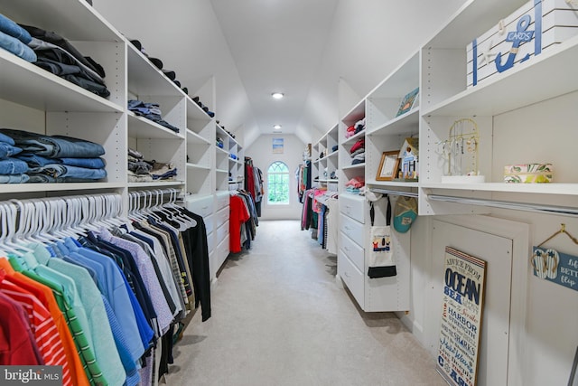 walk in closet featuring vaulted ceiling and light colored carpet