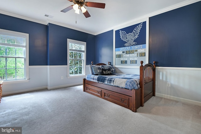 carpeted bedroom featuring a ceiling fan, baseboards, visible vents, and ornamental molding