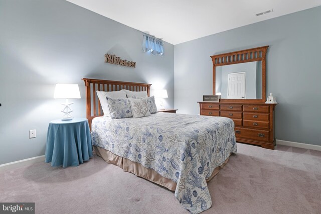 carpeted bedroom with visible vents and baseboards