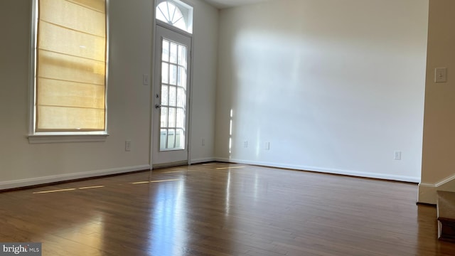 spare room with dark wood-style floors and baseboards