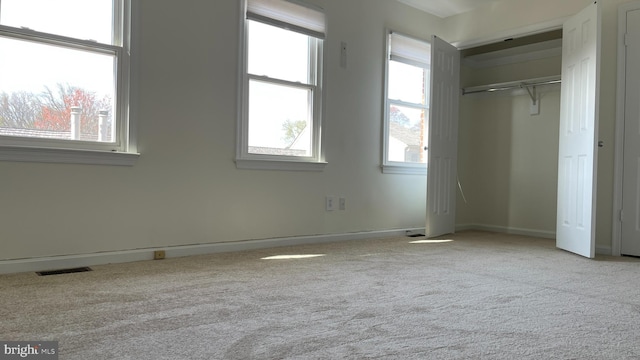 unfurnished bedroom featuring multiple windows and carpet flooring