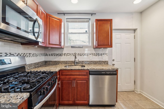 kitchen featuring light tile patterned flooring, stainless steel appliances, decorative backsplash, and a sink