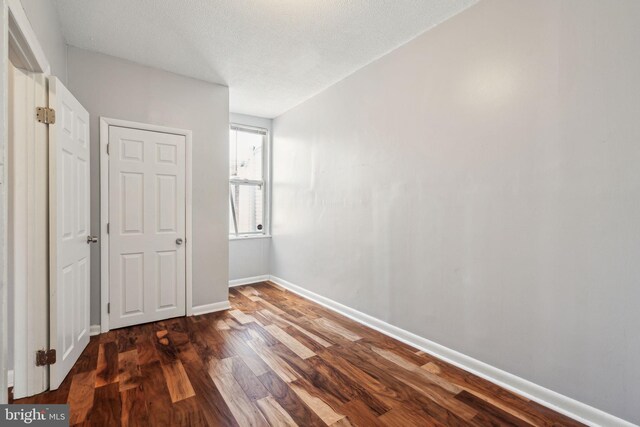 unfurnished bedroom featuring wood finished floors and baseboards